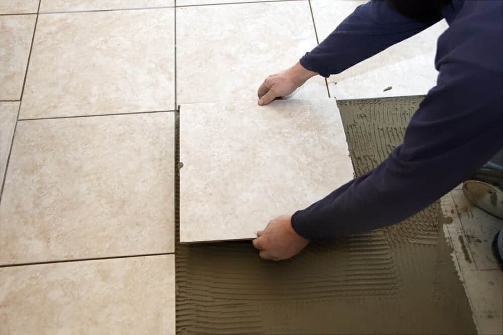 A man laying ceramic floor tile